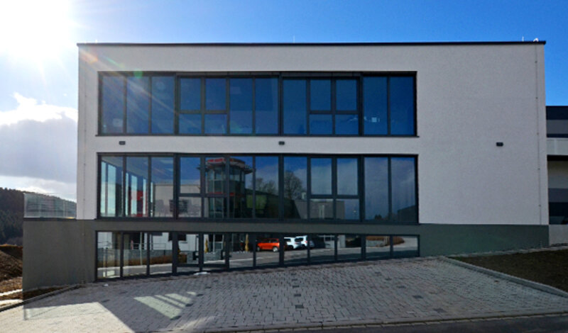 Das neue Bürogebäude von hydrophon mit einer großen Fensterfront.